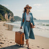 Woman in spring outfit with suitcase and menstrual pad, beach in background, representing travel prep during period.