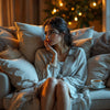 Woman on couch with tea, reflecting on emotions.